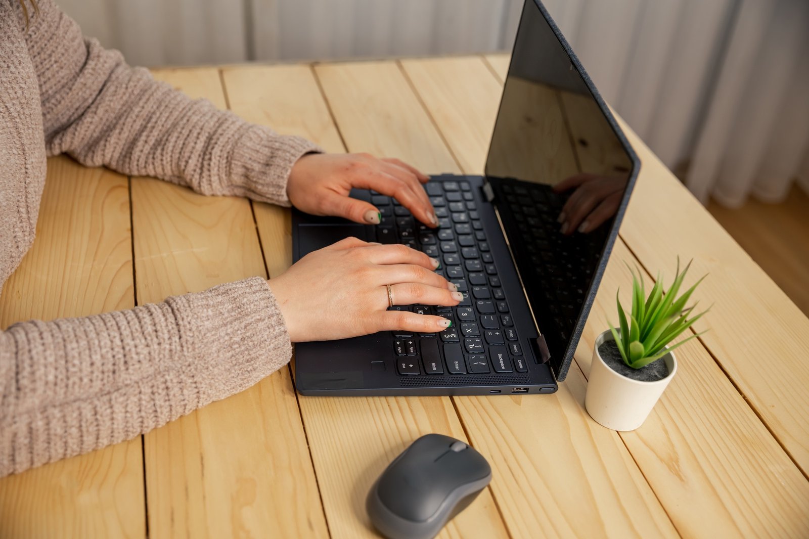 Young woman working on laptop. Female hands typing on pc keyboard.